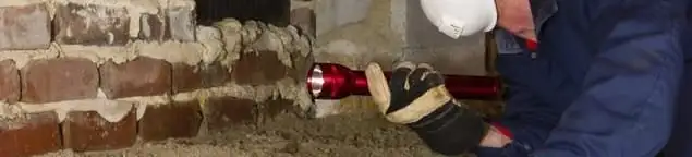Pest control technician inspecting a crawl space for ant activity and entry points in Providence, RI